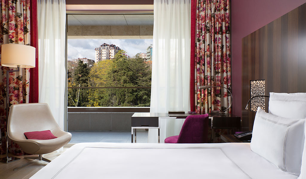 Swiss Advantage Zimmer mit breitem Doppelbett und Blick auf den Park im Swissôtel Kamelia